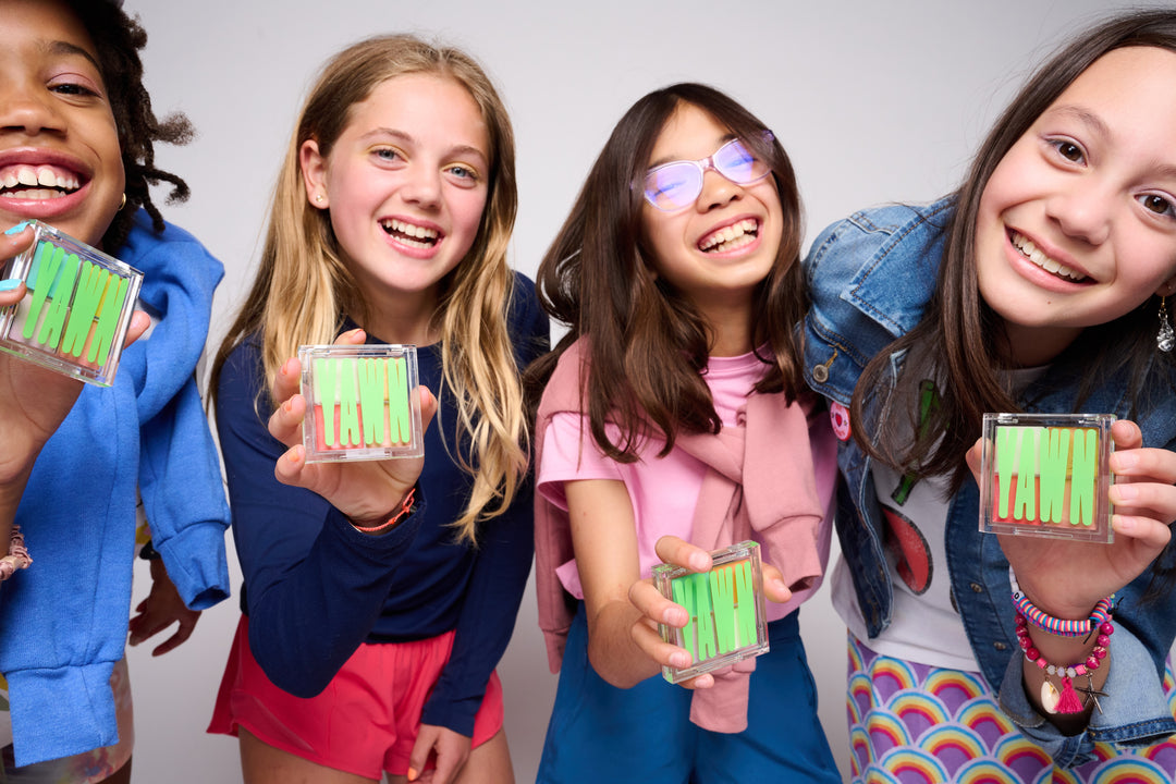 Photo of four girls, each one holding a YAWN eyeshadow palette towards the camera.